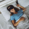 A sleep mask blocks light, reduces distractions, and improves sleep quality by creating a dark, calm environment for better relaxation.